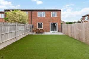 un patio trasero con valla y césped en Holyport - Three Bedroom House - Parking, en Maidenhead