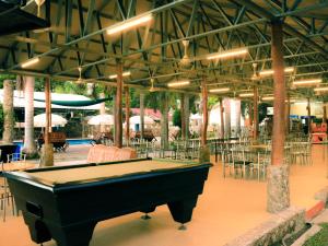 a pool table in a pavilion with tables and chairs at Timor Lodge in Dili