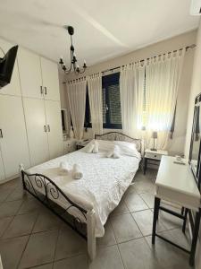 a bedroom with a white bed with a chandelier at Sunset Apartments in Gourna