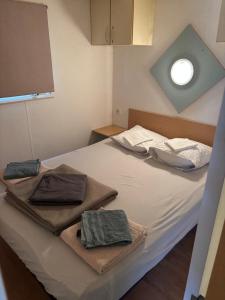 a bed with two towels sitting on top of it at Camping l'Horizon 30 in Les Mages