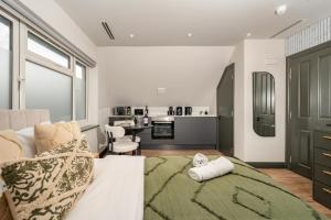 a living room with a bed and a kitchen at Arnos Grove Gem AC 1BR Sleeps 2 WiFi & Parking in New Southgate