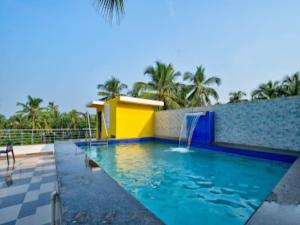 a swimming pool with a waterfall in a resort at Villa platinum 4 BHK Calangute in Calangute