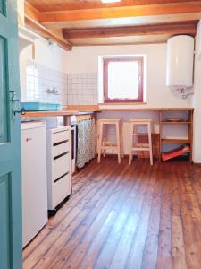 a kitchen with a counter and two stools at počitniška hiška MEDVEJKE in Slappe dʼIdria +10 photos