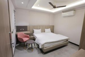 a bedroom with a bed and a pink chair at Hotel Vintage Villas in New Delhi +5 photos