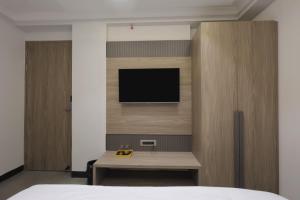 a bedroom with a bed and a tv on a wall at Hotel Vintage Villas in New Delhi
