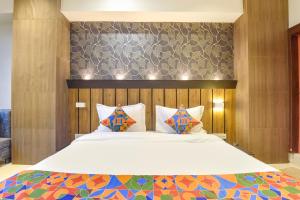 Un dormitorio con una gran cama blanca con paredes de madera. en Via The Max Glory, en Indore