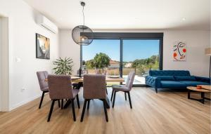a living room with a dining table and a blue couch at Stunning Home In Zaton in Zaton