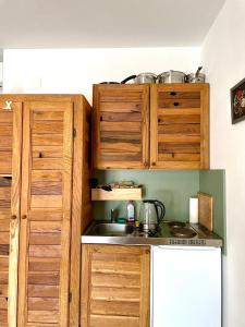 a kitchen with wooden cabinets and a sink at Bajic Apartmani in Seline +32 photos
