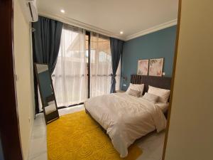 a bedroom with a bed and a large window at Résidence Akia - Jacuzzi privé & détente moderne in Pointe-Noire +71 photos