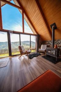 a living room with a fireplace and large windows at Livoz Suit Bungalov in Çayırdüzü +23 photos