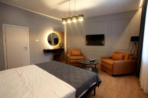 a bedroom with a bed and a couch and a chair at Portal Villa Apartments in Bitola