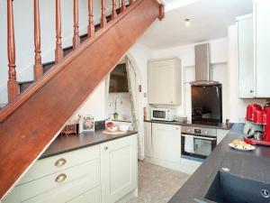 een keuken met witte kasten en een houten trap bij Bury Meadow Lodge - Exeter - Train 5 min walk - Parking in Exeter