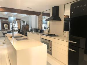 eine Küche mit weißen Arbeitsflächen und einem schwarzen Kühlschrank in der Unterkunft Valencia Luxury - Boutique El Carmen in Valencia