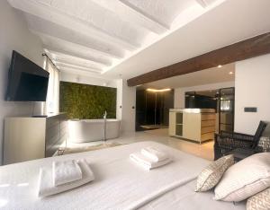 ein Schlafzimmer mit einem großen weißen Bett und ein Badezimmer in der Unterkunft Valencia Luxury - Boutique El Carmen in Valencia