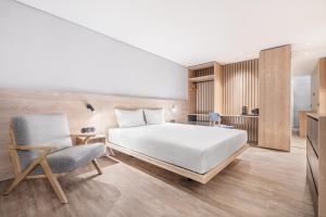 a hotel room with a bed and a chair at Moov Apartments Boavista in Porto