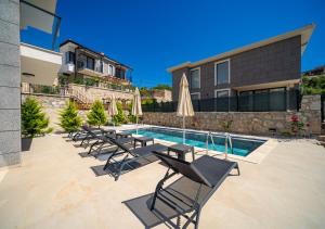 a group of chairs with umbrellas next to a swimming pool at Villa Poyraz in Kas