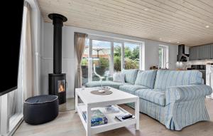Una sala de estar con un sofá y una chimenea. en Beautiful Home In Gudhjem With Wifi, en Gudhjem