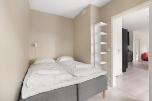 a bedroom with a bed with white sheets at 2BR Apt w Balcony by Oslo S and Munch in Oslo