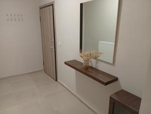a bathroom with a mirror and a vase on a shelf at Central apartment's in Trikala 2 in Tríkala