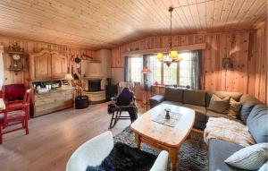 una sala de estar con un sofá y una mesa en Beautiful Home In Sjusjøen With Sauna, en Sjusjøen