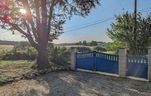 una recinzione blu con un albero in un campo di Maison Avec Piscine Et Etang a Tournon-dʼAgenais
