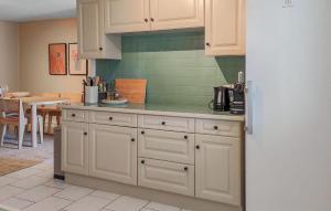 una cucina con mobili bianchi e un tavolo di Maison Avec Piscine Et Etang a Tournon-dʼAgenais