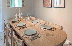 un tavolo in legno con sedie e una sala da pranzo di Maison Avec Piscine Et Etang a Tournon-dʼAgenais