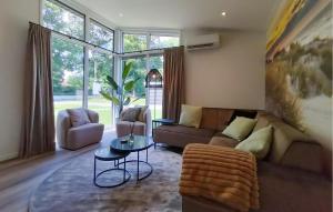 a living room with a couch and a table at Beautiful Home In Voorthuizen in Voorthuizen