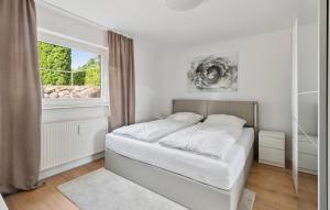 a white bedroom with a bed and a window at 1 Bedroom Amazing Apartment In Dassow in Dassow