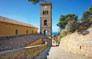 ein hoher Turm mit einer Uhr auf einem Gebäude in der Unterkunft Awesome Apartment In Santa Maria Di Castell in Santa Maria di Castellabate