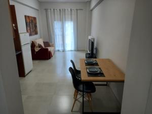 a room with a table and a chair and a television at Central apartment's in Trikala 2 in Tríkala