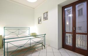 Schlafzimmer mit einem Bett und einer Glastür in der Unterkunft Awesome Apartment In Santa Maria Di Castell in Santa Maria di Castellabate