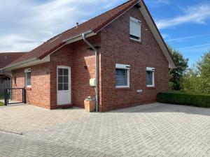 a red brick house with a large driveway at Skippersin5 in Greetsiel