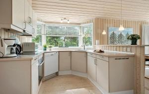 a kitchen with white cabinets and a large window at 3 Bedroom Stunning Home In Kalundborg in Kalundborg