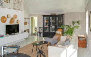 a living room with a couch and a tv at 1 Bedroom Gorgeous Home In Stallarholmen in Stallarholmen