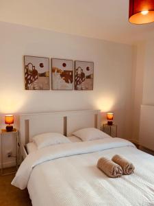 two beds in a bedroom with three pictures on the wall at Warm and welcoming apartment in Serris