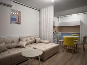 a living room with a couch and a table and a kitchen at Apartel Elia 2 in Mamaia Nord +30 photos
