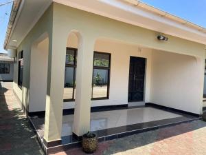 ein weißes Gebäude mit einem Innenhof mit einer Topfpflanze in der Unterkunft Emmalanta Homes in Arusha