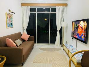 a living room with a couch and a tv at FA Seaview Glory Beach Resort in Port Dickson
