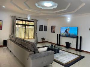 ein Wohnzimmer mit Couch und Flachbildfernseher in der Unterkunft Emmalanta Homes in Arusha