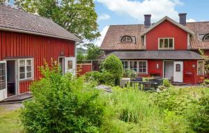 a red house next to a red house at 2 Bedroom Lovely Home In Sättersta Tystberga 