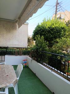 a patio with a table and chairs on a balcony at Maria Cozy Getaway in Glyfada in Athens