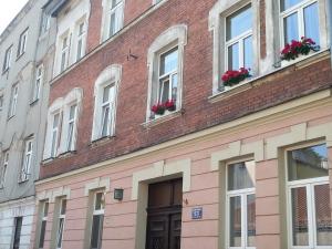 un edificio in mattoni con fiori alle finestre di Apartment Old Cracow a Cracovia