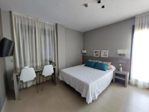 Un dormitorio con una cama y una mesa y sillas. en Hotel Miguel Sanchez, en Alhaurín de la Torre 35 fotos más