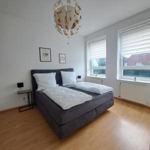 a bedroom with a bed and a chandelier at Das Stadthaus, mit Terrasse und Garten in Diepholz +17 photos