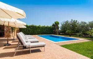 a pool with two lounge chairs and an umbrella at Can Sanchez in Campos