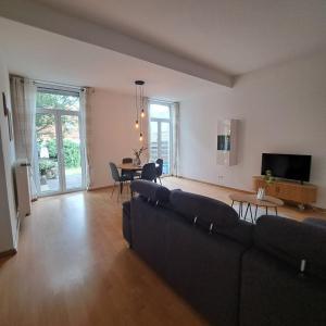 a living room with a couch and a table at Das Stadthaus, mit Terrasse und Garten in Diepholz