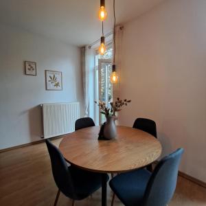 a dining room table with chairs and a vase with flowers at Das Stadthaus, mit Terrasse und Garten in Diepholz