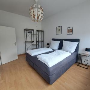 a bedroom with a bed and a chandelier at Das Stadthaus, mit Terrasse und Garten in Diepholz