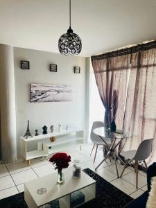 a white living room with a table and chairs at Cloud 10 Hideaway in Pretoria